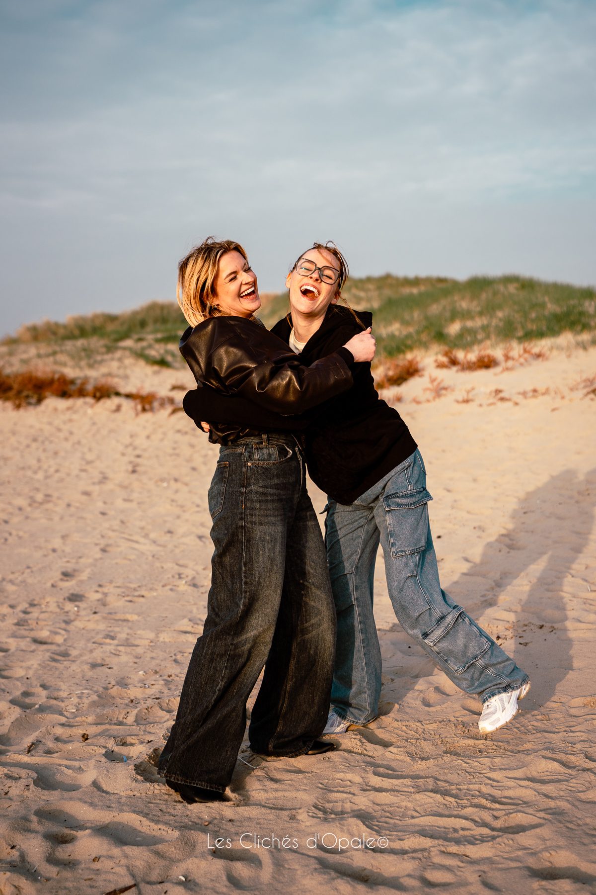 Deux amies complices riant sur la plage de la Côte d'Opale