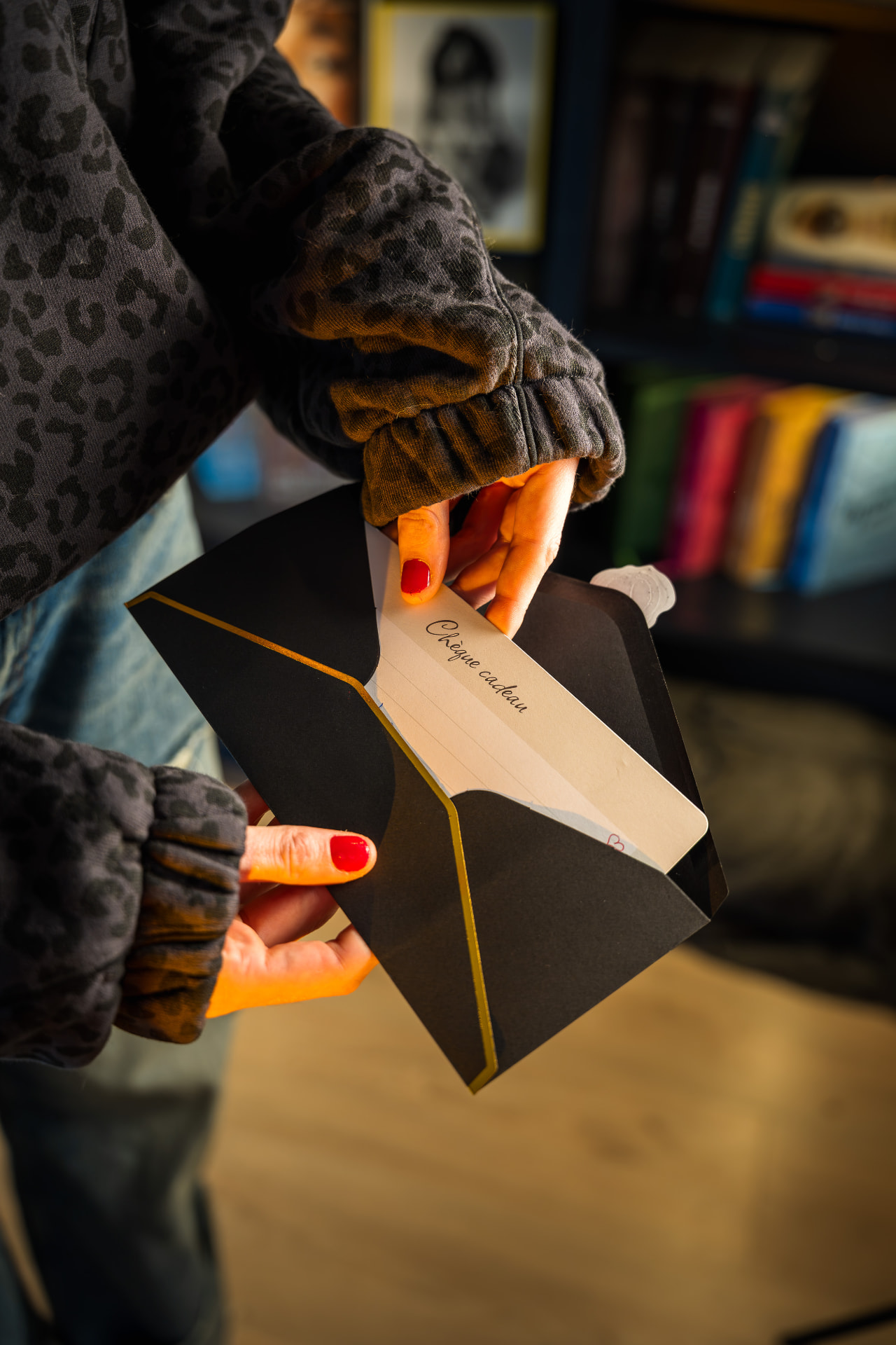 Chèque cadeau Les Clichés d'Opale glissé dans son enveloppe noire et or